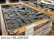Large wooden crate holds an array of square granite cobblestones, each uniquely textured and shaped, ready to pave paths and streets with timeless elegance. Стоковое фото, фотограф Татьяна Степанищева / Фотобанк Лори