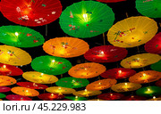Bright paper chinese umbrellas background. Dynamic advertising with burst of colorful umbrellas. lively image radiates excitement and is an ideal representation of thrilling aerial experiences. Стоковое фото, фотограф Павел Муравьев / Фотобанк Лори