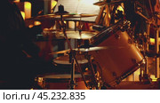 A drummer actively playing a drum kit on a candlelit stage. Shot in slow motion. The background is decorated with many candles, adding to the atmosphere of the concert. Стоковое видео, видеограф Воловодов Владимир / Фотобанк Лори