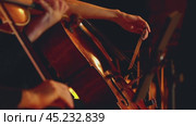 A close-up of a musician playing the cello. A woman's hand with a bow is clearly visible. Slow motion. A concert of classical music. Стоковое видео, видеограф Воловодов Владимир / Фотобанк Лори