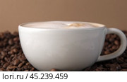 Drop of milk falling in a white cup with black coffee. Side View. Slow Motion. Coffee droplet. Roasted coffee beans background. Freshly brewed latte cappuccino. Close up. Coffee product advertising. Стоковое видео, видеограф Марина Демидюк / Фотобанк Лори
