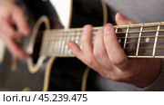 Playing the guitar. Strumming black acoustic guitar. Musician plays music. Man fingers holding mediator. Male hand playing guitar neck in dark room. Unrecognizable person rehearsing, fretboard closeup. Стоковое видео, видеограф Марина Демидюк / Фотобанк Лори