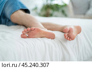 Foot pain, corns and calluses, dry skin on legs, tired man resting after work, male feet, podiatry concept. Стоковое фото, фотограф Станислав Тарко / Фотобанк Лори