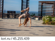 A young woman in a tracksuit performs physical exercises in a summer park. Стоковое фото, фотограф Андрей Аркуша / Фотобанк Лори