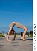 Fitness portrait young athletic woman doing gymnastics on blue sky background. Стоковое фото, фотограф Андрей Аркуша / Фотобанк Лори