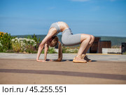 A young woman in a tracksuit performs physical exercises in a summer park. Стоковое фото, фотограф Андрей Аркуша / Фотобанк Лори