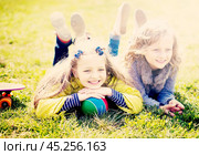 Two girls lie on grass. Стоковое фото, фотограф Татьяна Яцевич / Фотобанк Лори