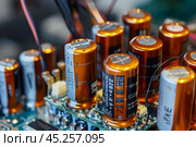 Close up of electrolytic capacitors on circuit board. Стоковое AI-изображение, AI-художник Иван Рябоконь / Фотобанк Лори