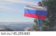 The Russian flag is on the shoulders of a girl standing against the backdrop of the Caucasus mountains. Unity Day in Russia. Стоковое видео, видеограф Екатерина Золина / Фотобанк Лори