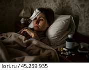 1. "Женщина с температурой: больная пациентка в  квартире" 2. "Постельный режим: женщина с платком на лбу в домашней обстановке" 3. "Домашнее лечение: больная женщина с таблетками на  диване" 4. "Головная боль и простуда: женщина в постели в  квартире" 5. "Болезнь в домашних условиях: женщина с платком на лбу в драматичной обстановке" Стоковое AI-изображение, AI-художник Сергей Расторгуев / Фотобанк Лори