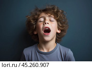 Young boy standing in front of wall, whim, looking up with surprised and state of shock or confusion, he heard or seen something unexpected or terrible. He very emotional expression sings songs. Стоковое AI-изображение, AI-художник Sergey Grishin / Фотобанк Лори