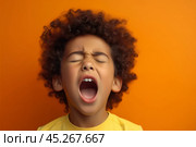 Extremely Upset black curly haired boy in t shirt screaming and crying with opened mouth and closed eyes against orange yellow color wall. Стоковое AI-изображение, AI-художник Sergey Grishin / Фотобанк Лори