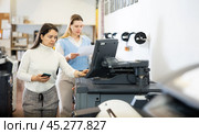 Team of professionals works on printing equipment in printer shop. Стоковое фото, фотограф Яков Филимонов / Фотобанк Лори