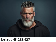 Despise. Angry and grumy Caucasian gray-haired bearded man sulking, furrow eyebrows and staring with anger and contempt, boiling from furious emotions, standing over grey background. Стоковое AI-изображение, AI-художник Sergey Grishin / Фотобанк Лори