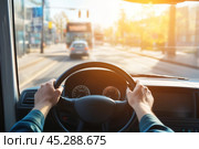 Driver turns steering wheel of truck, bus at sunset. POV. Skilled chauffeur drives lorry to deliver freight. Cargo shipping service. Journey. Drivers Hands on a wheel. Travel. Personal Perspective. Стоковое AI-изображение, AI-художник Марина Демидюк / Фотобанк Лори
