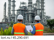 Engineers in Safety Gear Conducting Comprehensive Assessments of Industrial Facilities. Civil employees team review project plan at industrial facility factory building. Construction Industry. Outdoor. Стоковое AI-изображение, AI-художник Марина Демидюк / Фотобанк Лори