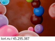 Colorful chocolate dragee candies floating against chocolate background, showcasing variety candy is perfectly round, offering visual feast of glossy. 3d rendering. Стоковое фото, фотограф Павел Муравьев / Фотобанк Лори