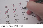 Hand marking a specific date on a calendar with a closeup view to emphasize details. Стоковое видео, видеограф Громов Александр / Фотобанк Лори