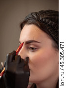 Beautician drawing eyebrow shape on client face using pencil. Стоковое фото, фотограф Юрий Поздников / Фотобанк Лори