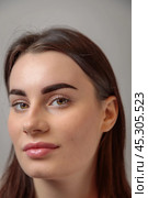 Portrait of beautiful young woman showing perfect eyebrows after microblading treatment. Стоковое фото, фотограф Юрий Поздников / Фотобанк Лори