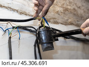 An electrician solders twisted electrical wires in a house under construction. Connection and twisting of cables. Стоковое фото, фотограф Коханова Наталья / Фотобанк Лори