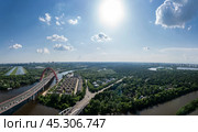 A breathtaking aerial view captures a vibrant cityscape with an arching bridge, lush green parks, and flowing rivers, all illuminated by the sun in a clear blue sky (2020 год). Стоковое фото, фотограф Алексей Климкин / Фотобанк Лори