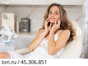 Young joyful woman examining her face after cosmetic procedure. Стоковое фото, фотограф Яков Филимонов / Фотобанк Лори