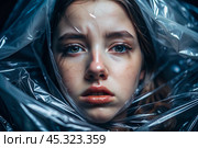 The girl is wrapped in cellophane or a bag. The girl is suffocating. Plastic pollution of the planet. Environmental hazard. Reducing the reuse of plastic. Recycling. The concept of garbage. Стоковое AI-изображение, AI-художник Photojuli / Фотобанк Лори