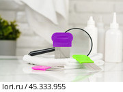 Lice treatment product next to a nit comb and magnifying glass. Стоковое фото, фотограф Сергей Толмачёв / Фотобанк Лори