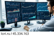 Professional at desk with multiple monitors showing financial charts, data analysis graphs, stock market trends, modern office setting, investment strategies, market research, digital technology. Стоковое AI-изображение, AI-художник Павел Муравьев / Фотобанк Лори