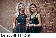 Young Punk Women Laughing Together Against Brick Wall Urban Style Friendship. Youthful Rebellious Spirit. Стоковое AI-изображение, AI-художник Павел Муравьев / Фотобанк Лори