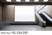 Mockup of advertising space in metro station, clean white billboard for marketing messages, pedestrian underpass with moving escalator, city environment for public advertisement. Стоковое AI-изображение, AI-художник Павел Муравьев / Фотобанк Лори