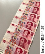 Close-up of Chinese Yuan paper money. Diagonal row of 100 yuan bills on table. Money financial background. Flat lay, close-up, top view. Стоковое фото, фотограф Виктория Катьянова / Фотобанк Лори