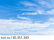 Blue sky with fluffy white cirrus clouds. The sky is clear and bright, and the clouds are scattered throughout the sky. Scene is peaceful and serene, copy space. High quality photo. Стоковое фото, фотограф Ирина Михайличенко / Фотобанк Лори