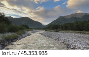 Video of beautiful evening landscape with mountain river at sunset with Eastern Sayan Mountain ranges in the distance and colorful clouds on blue sky. Siberia, Buryatia, Tunka valley, Arshan. Стоковое видео, видеограф Виктория Катьянова / Фотобанк Лори