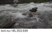 Video of a turbulent flow of water of a mountain river with a stone pyramid. Clean natural water. Стоковое видео, видеограф Виктория Катьянова / Фотобанк Лори