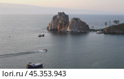 Video of Baikal Lake on summer sunset. Tourists ride a motorboat near the famous Shamanka Rock - Olkhon Island attractions. Стоковое видео, видеограф Виктория Катьянова / Фотобанк Лори