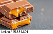 Chocolate bars with gooey caramel filling tempt the taste buds, AI. Стоковое AI-изображение, AI-художник Сергей Старуш / Фотобанк Лори