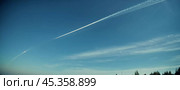 Chemtrail conspiracy theory. Long-lasting condensation trails left in sky by high-flying aircraft are actually chemtrails consisting of chemical or biological agents, sprayed for nefarious purposes. Стоковое AI-изображение, AI-художник Юлия Петровская / Фотобанк Лори