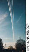 Chemtrail conspiracy theory. Long-lasting condensation trails left in sky by high-flying aircraft are actually chemtrails consisting of chemical or biological agents, sprayed for nefarious purposes. Стоковое AI-изображение, AI-художник Юлия Петровская / Фотобанк Лори