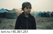 Young refugee girl standing in refugee camp. Стоковое видео, видеограф Данил Руденко / Фотобанк Лори
