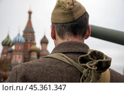 Мужчина в военной форме Великой Отечественной войны идет по Красной площади в центре города Москвы на фоне храма Василия Блаженного, Россия. Редакционное фото, фотограф Николай Винокуров / Фотобанк Лори