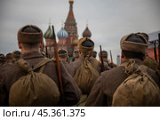 Люди в форме солдат и с оружием Великой Отечественной войны идут по Красной площади в центре города Москвы на фоне Московского кремля, Россия. Редакционное фото, фотограф Николай Винокуров / Фотобанк Лори