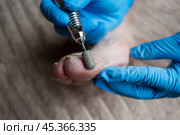 Professional hardware pedicure, elderly woman with cracked skin on her foot at a podiatrist's appointment, chiropody and podology concept. Стоковое фото, фотограф Станислав Тарко / Фотобанк Лори