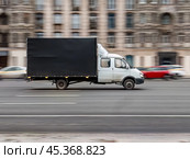 Gazelle truck rides on the road. White and black cargo auto GAZ Gazelle driving on city street. Редакционное фото, фотограф Константин Григорьев / Фотобанк Лори