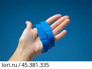 Синий водонепроницаемый бесконтактный RFID браслет на руке на фоне синего неба. Стоковое фото, фотограф Дорощенко Элла / Фотобанк Лори