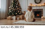 Christmas at home. Waiting for miracles and a gift. A cute little boy is sitting on the floor in a bright living room decorated for Christmas and New Year holidays. Стоковое AI-изображение, AI-художник Photojuli / Фотобанк Лори