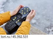 Ice cleats for shoes, rubber winter traction over boots, snow grips to provide grip on snowy and icy surfaces. Стоковое фото, фотограф Владимир Григорьев / Фотобанк Лори