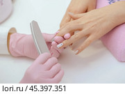 manicure worker smoothing customers nails with nail file. Стоковое фото, фотограф Сергей Толмачёв / Фотобанк Лори