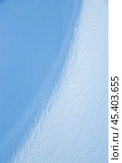 Snow texture. Wind sculpted patterns on snow surface. Wind in the tundra and in the mountains on the surface of the snow sculpts patterns and ridges (sastrugi). Arctic, Polar region. Winter background. Стоковое фото, фотограф Андрей Степанов / Фотобанк Лори